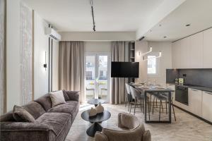 a living room with a couch and a kitchen with a table at Agathe Apartment in Ierapetra