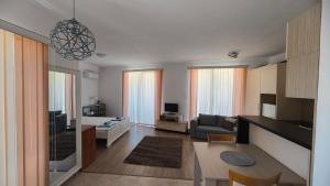 a living room with a couch and a dining room at Студио JASMIN in Tsarevo