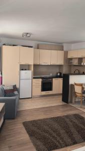 a kitchen with white cabinets and a couch and a table at Студио JASMIN in Tsarevo +5 photos