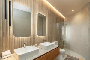 a bathroom with two sinks and a toilet and a mirror at Agathe Apartment in Ierapetra +16 photos
