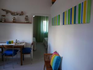 een eetkamer met een tafel en stoelen en een kamer bij Appartamento Tino in Castiglione della Pescaia