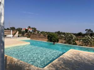 a large swimming pool with blue water at Monte da Casa Branca by Hi Alentejo in São Bartolomeu da Serra