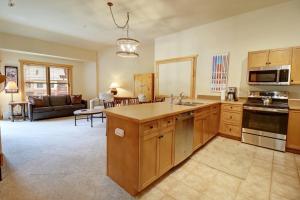 a kitchen with wooden cabinets and a living room at CS425 Copper Springs in Copper Mountain
