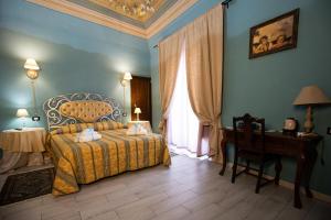 a bedroom with a bed and a desk and a window at Palazzo Diamante in Calascio