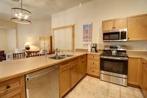 a kitchen with stainless steel appliances and wooden cabinets at CS425 Copper Springs in Copper Mountain