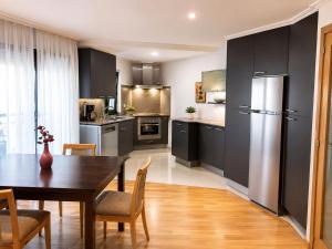 a kitchen with a dining room table and a refrigerator at Casa Turística Mareira O Grove in O Grove