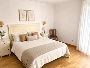 a bedroom with a large white bed with pillows at Casa Turística Mareira O Grove in O Grove +13 photos
