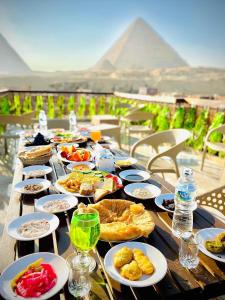 a long wooden table with plates of food on it at Comfort Pyramids Inn in Cairo