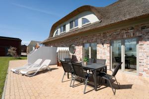 a patio with a table and chairs and a house at Reiterhof Rickert Glücksklee in Meeschendorf