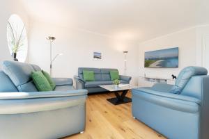 a living room with blue couches and a table at Reiterhof Rickert Glücksklee in Meeschendorf
