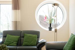 a living room with a couch and a round mirror at Reiterhof Rickert Glücksklee in Meeschendorf