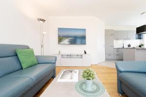 a living room with two blue couches and a table at Reiterhof Rickert Glücksklee in Meeschendorf +32 photos