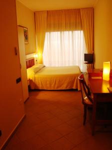 a hotel room with a bed and a desk and a window at Hotel Residence Due Mari in Marcellinara