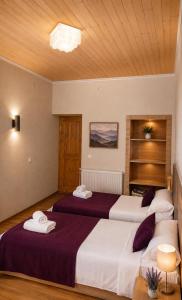two beds in a hotel room with purple sheets at Teo Guesthouse and Camping in Mestia in Mestia