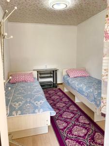 a room with two beds and a desk in it at Alaman Guest House in Kaji-Say