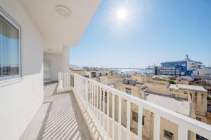 a balcony with a view of a city at Sandy Soul in Birżebbuġa