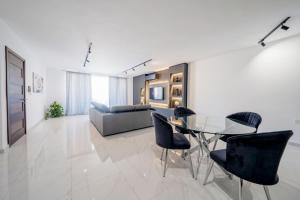 a living room with a glass table and chairs at Sandy Soul in Birżebbuġa