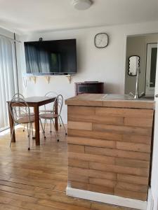 a kitchen with a table and chairs and a clock on the wall at Maison familiale in Froid-Chapelle