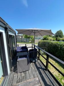 a deck with two chairs and an umbrella at Maison familiale in Froid-Chapelle +2 photos