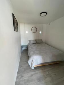 a bedroom with a bed and a clock on the wall at Maison familiale in Froid-Chapelle