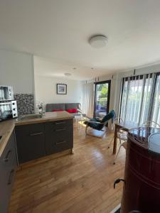 a kitchen and living room with a table and chairs at Maison familiale in Froid-Chapelle