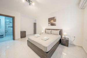 a bedroom with a bed with two towels on it at Sandy Soul in Birżebbuġa