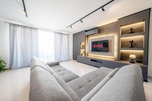 a living room with a large couch and a tv at Sandy Soul in Birżebbuġa