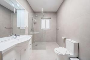 a white bathroom with a sink and a toilet at Sandy Soul in Birżebbuġa +29 photos