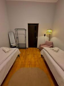 a room with two beds and a lamp in it at Guest House Germani in Telavi