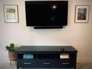 a flat screen tv hanging on a wall at The Bunker - Ski Shuttle Shopping Center in Stowe