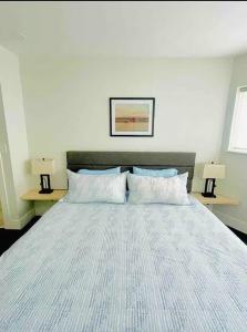 a bedroom with a large bed with two lamps at The Bunker - Ski Shuttle Shopping Center in Stowe +11 photos
