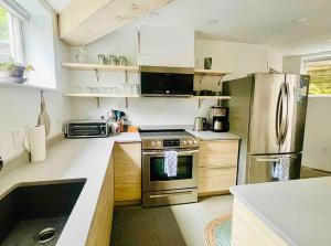a kitchen with a stainless steel stove and refrigerator at The Bunker - Ski Shuttle Shopping Center in Stowe