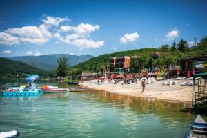 a group of boats in the water at a beach at Lakeside Cabin in Jablanica