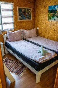 a bed with a stuffed animal sitting on top of it at Lakeside Cabin in Jablanica