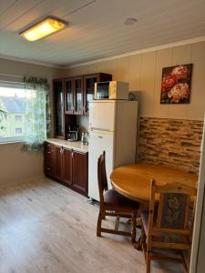 a kitchen with a table and a white refrigerator at Arctic View Apartament Vardø in Vardø