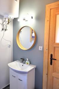 a bathroom with a sink and a mirror at Domki Wczasowe Mielenko in Mielenko +22 photos