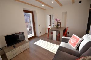 a living room with a couch and a television at Cà Giuel in Chiesa in Valmalenco