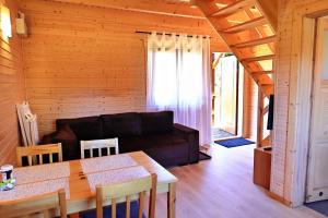 a living room with a couch and a table at Domki Wczasowe Mielenko in Mielenko