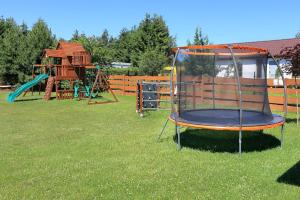 a playground with a trampoline in the grass at Domki Wczasowe Mielenko in Mielenko