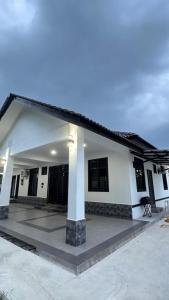 a large white house with a lot of windows at Baba Homestay in Macang