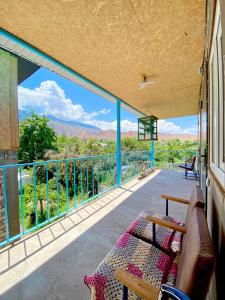 a balcony with a couch and a view of the mountains at Alaman Guest House in Kaji-Say