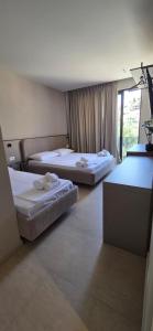 a room with two beds and a television at Emili Premium Residence in Qeparo