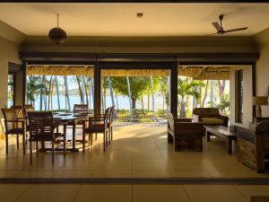 a dining room with a table and a view of the ocean at Beachfront Villa with Pool & Sunset Views in Rivière Noire