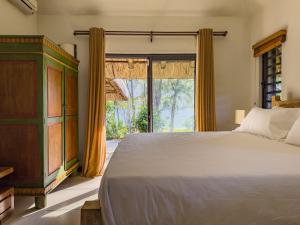 a bedroom with a bed and a large window at Beachfront Villa with Pool & Sunset Views in Rivière Noire