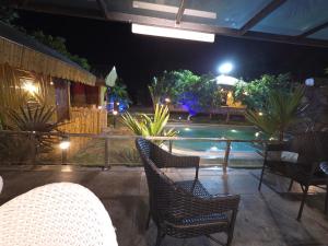 a patio with chairs and a swimming pool at night at Rajashree Multipurpose Resort in Solapur +2 photos