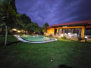 a swimming pool in the yard of a house at night at Rajashree Multipurpose Resort in Solapur