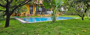 a swimming pool in the yard of a house at Rajashree Multipurpose Resort in Solapur