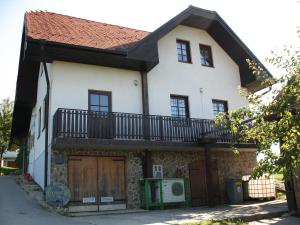 a white house with a balcony on top of it at Turistična kmetija Dervarič in Ljutomer