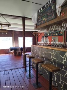 a bar with wooden stools in a restaurant at Pieza con vista Espacio Rio Chovellen in De Cauquenes