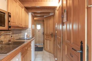a kitchen with wooden cabinets and a sink at 6 pers, proche pistes et commerces in Morillon +12 photos